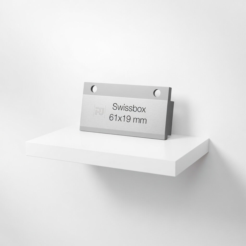 Graviertes Swissbox Sonnerieschild aus natur-eloxiertem Aluminium, Mass 61 x 28 mm, mit zwei Bohrungen am oberen Rand und einem Gravierfeld von 61 x 19 mm.